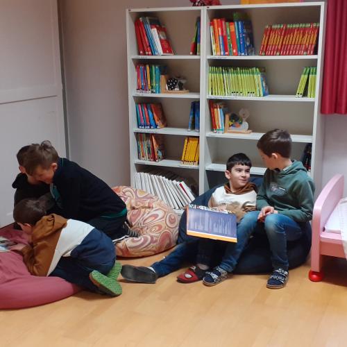 Kinder mit Büchern auf Sitzsäcken