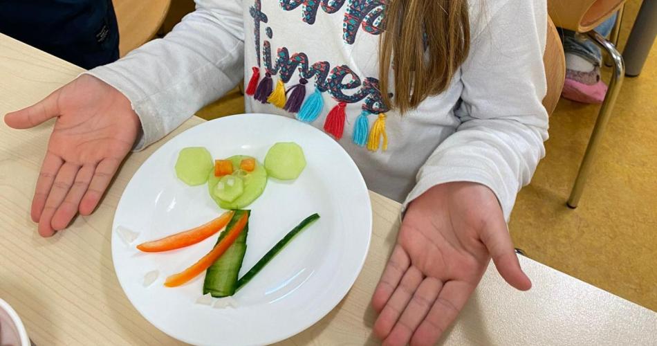 Mädchen vor Teller mit Gemüse