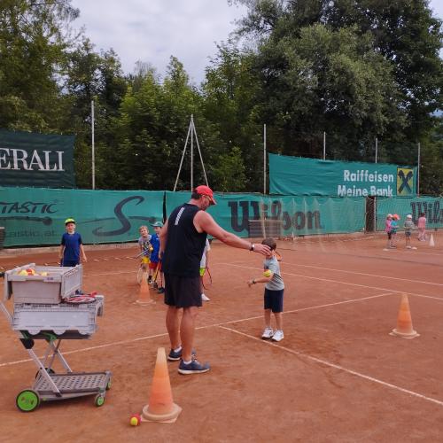 Tennislehrer mit Kind