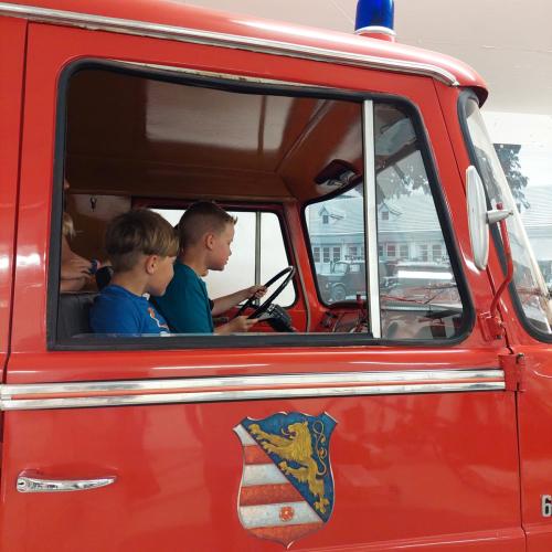 Zwei Buben in einem alten Feuerwehrauto