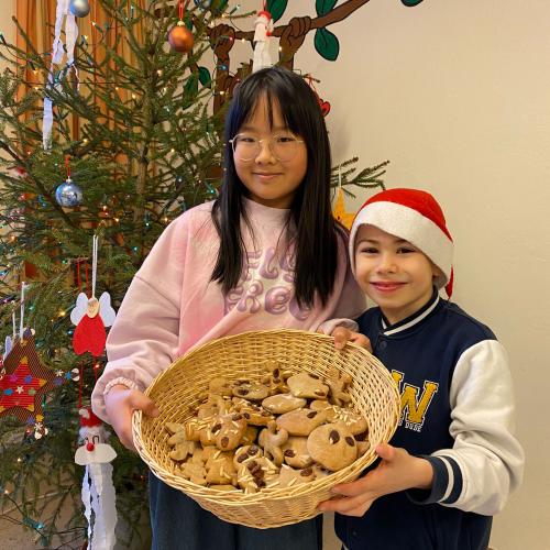 zwei Kinder mit einem Korb voller Kekse