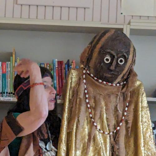 Frau und Figur mit Maske
