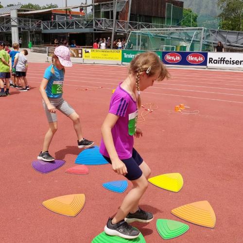 Kinder balancieren auf bunten Steinen