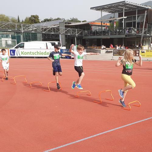 Kinder laufen über Sportplatz