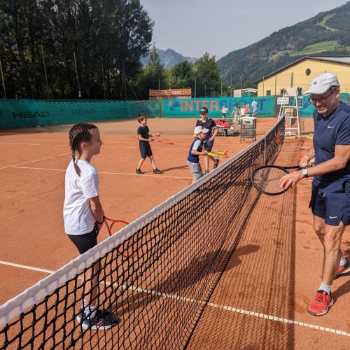 Kind und Mann an Tennisnetz