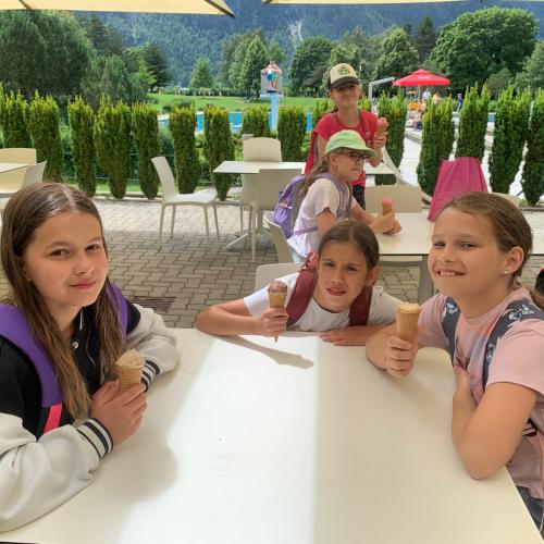 Mädchen sitzen um Tisch und essen Eis