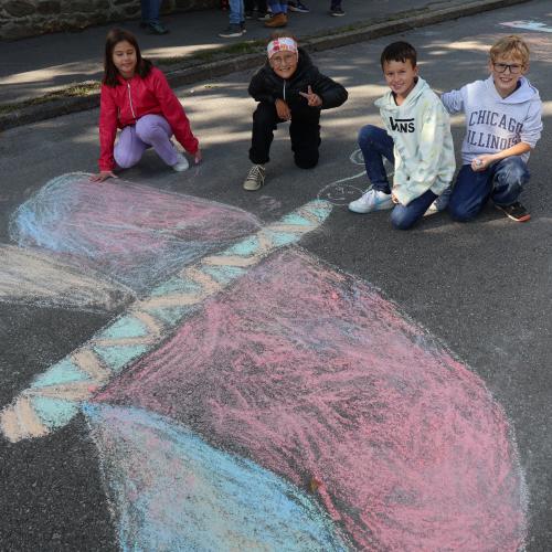 Kinder malen großen Schmetterling auf die Straße