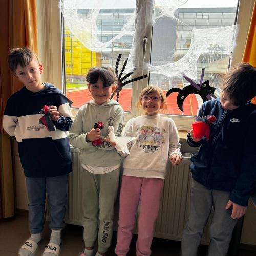 Kinder vor Fenster mit Papierspinnen