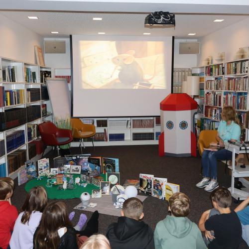 Kinder sitzen vor Leinwand