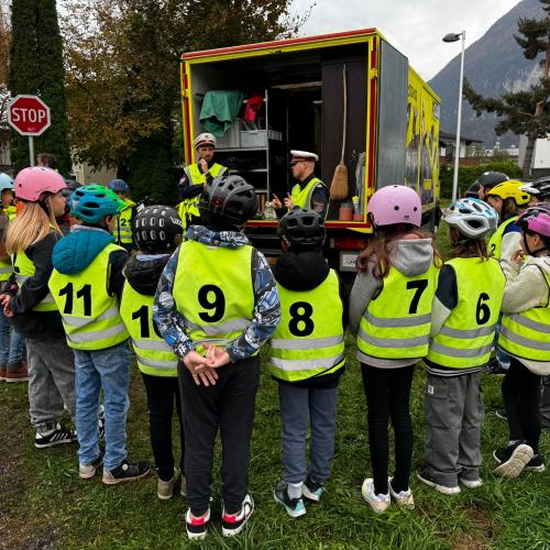 Kinder mit Warnwesten stehen im Kreis