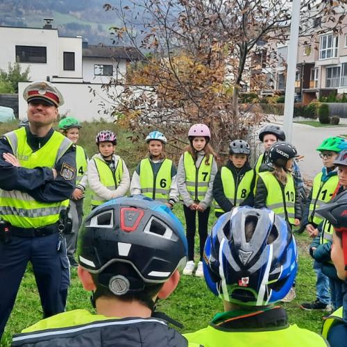 Polizisten und Kinder mit gelben Warnwesten