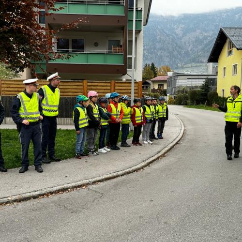Polzisten und Kinder mit gelben Warnwesten