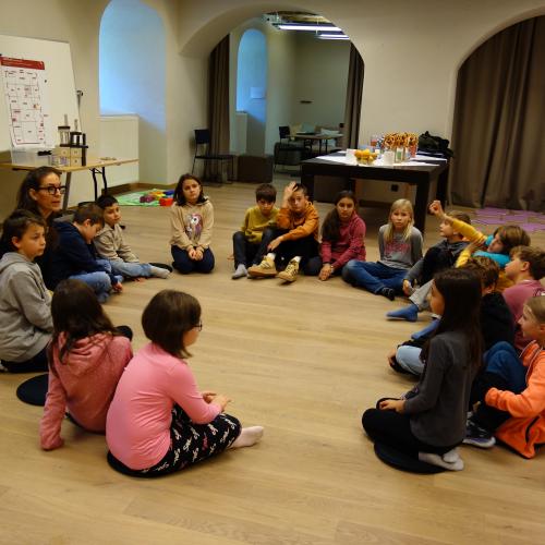 Kinder sitzen im Kreis auf dem Boden