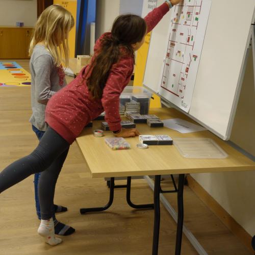 Mädchen an Tisch und Plakat