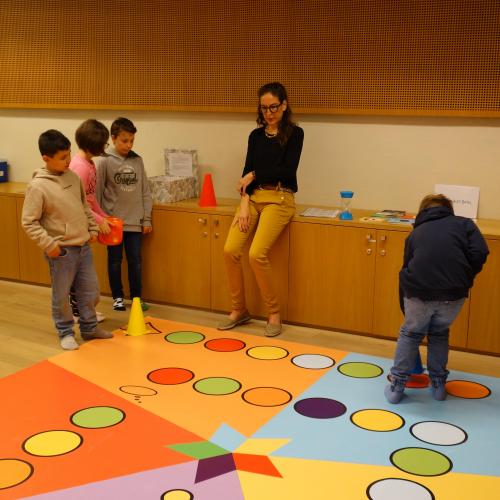 Kinder und Frau mit buntem Teppich