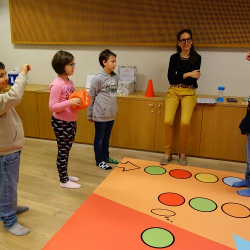 Kinder und Frau vor buntem Teppich
