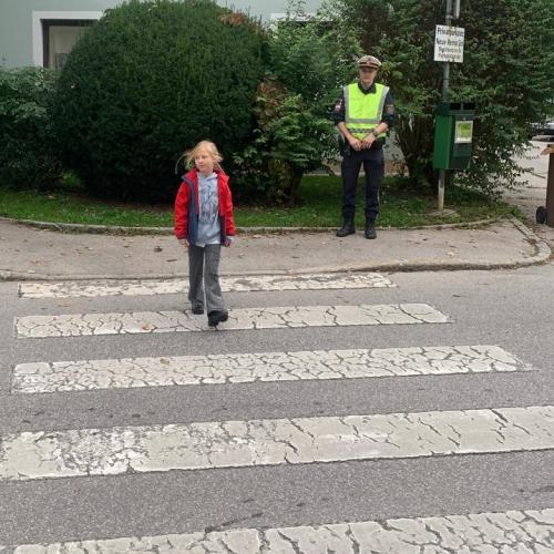 Polizist und Kind am Zebrastreifen