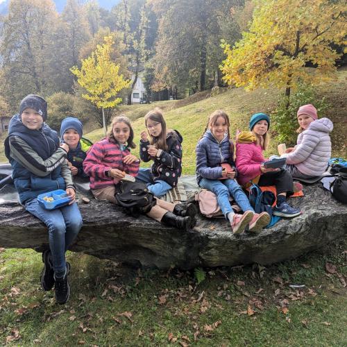 Kinder sitzen auf großem Stein