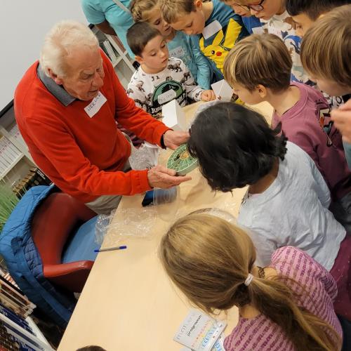 Kinder und zwei Erwachsene an Tisch