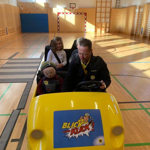 Mann und Kinder in kleinem gelben Auto