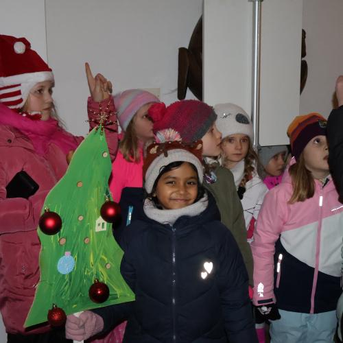 Kinder mit Weihnachtsbaum aus Pappe