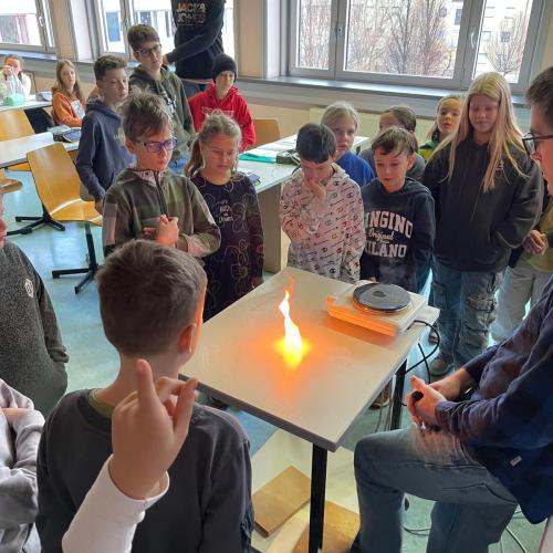 Kinder um einen Tisch mit Flamme