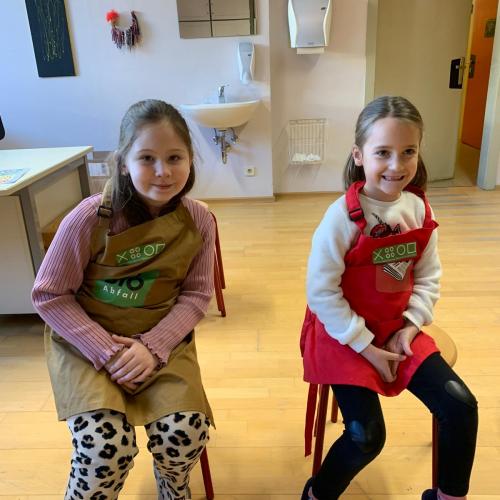 zwei Mädchen sitzen auf Hockern