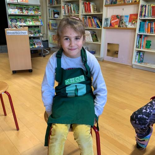 ein Kind sitzt auf Hocker