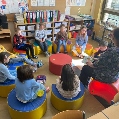 Frau und Kinder sitzen im Kreis