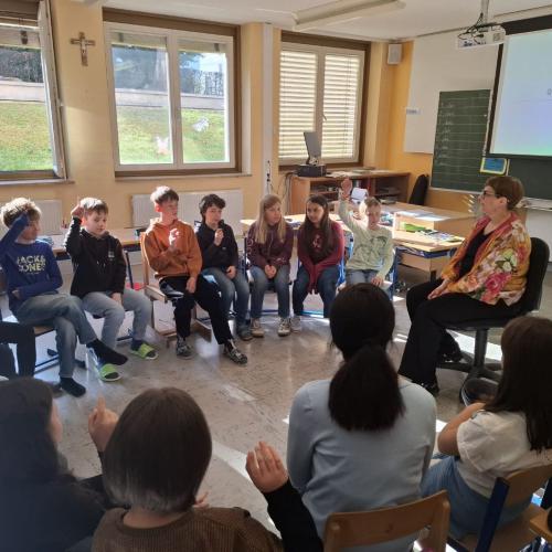 Kinder sitzen in Klassenzimmer im Kreis