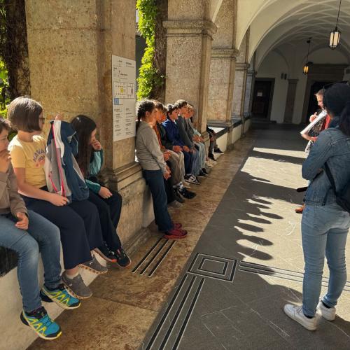 Kinder sitzen in Arkadenhof