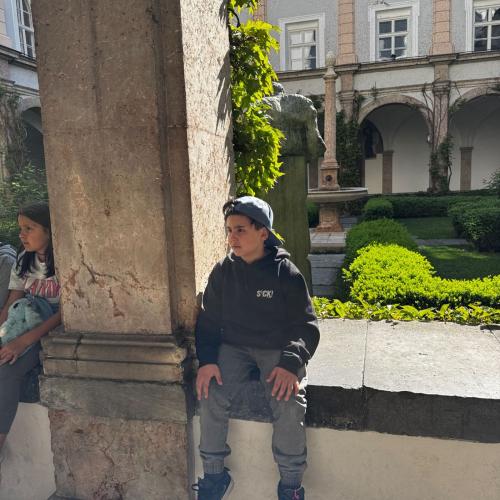Kind sitzt auf Mauer