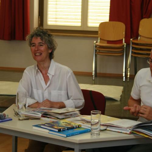 Frau und Mann sitzen an Tisch mit Büchern