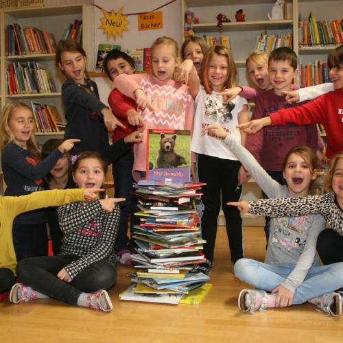 Kinder und ein Stoß Bücher