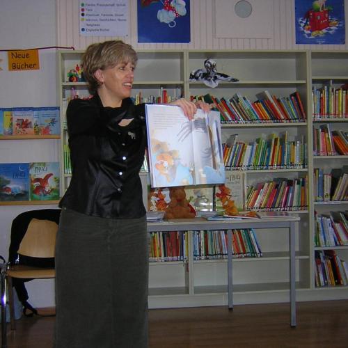 Frau zeigt aufgeschlagenes Buch