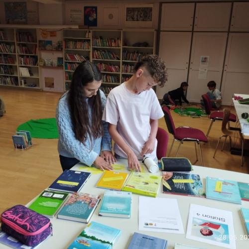 zwei Kinder und Bücher auf einem Tisch