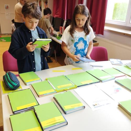 zwei Kinder und Bücher auf einem Tisch