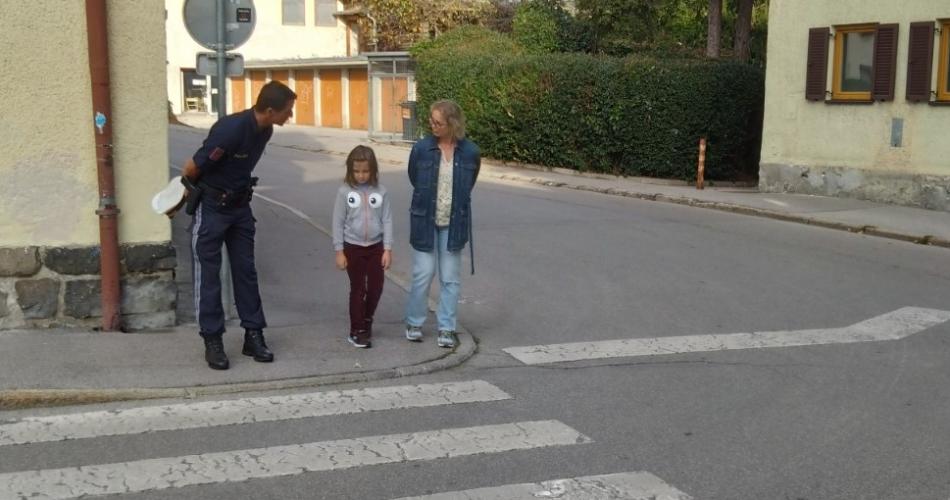 Polizist und Kind mit Frau am Straßenrand