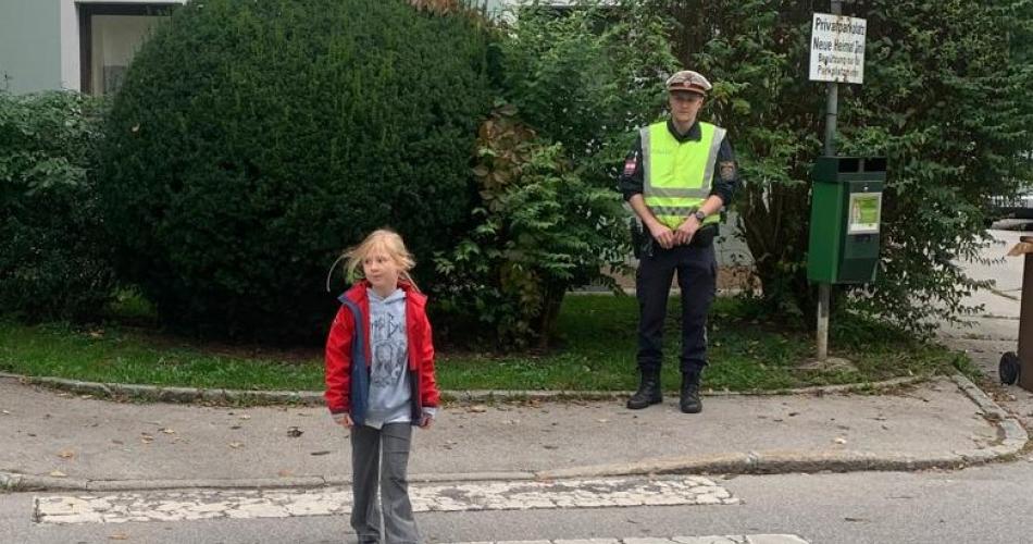 Polizist und Kind am Zebrastreifen