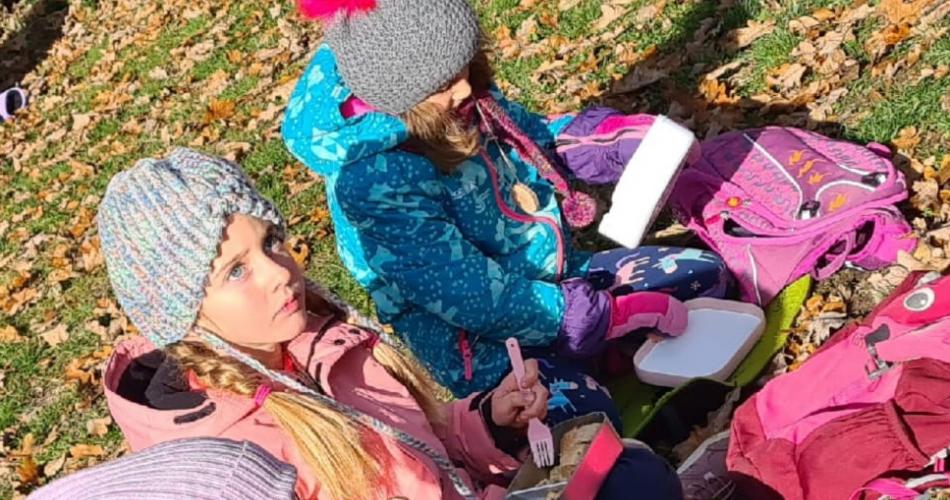 Kinder sitzen auf Wiese